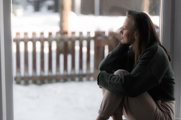 Tužna, zamišljena žena sedi napolju