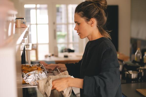 Žena ubacuje jelo u rernu