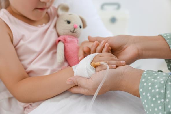 Mama drži devojčicu u bolnici za ruke