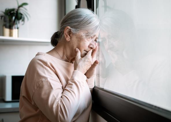 Zabrinuta baka gleda kroz prozor