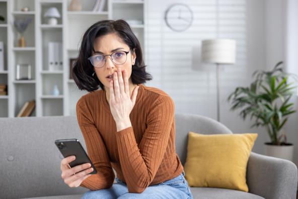 Zabrinuta žena drži telefon