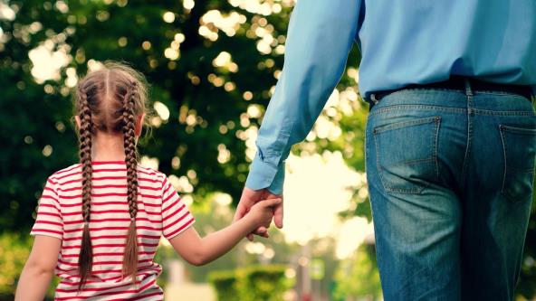Devojčica drži tatu za ruku