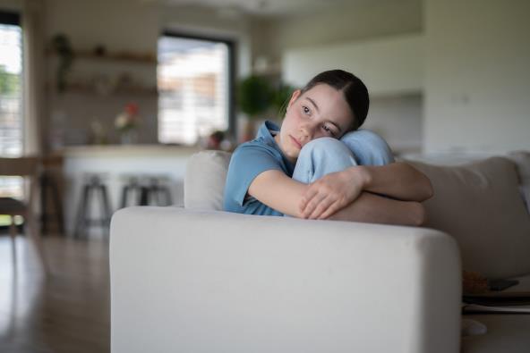 Usamljena devojčica sedi na kauču