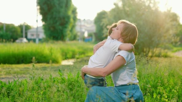 Majka i sin se grle napolju
