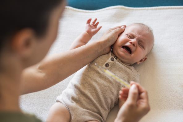 Mama proverava bebi temperaturu