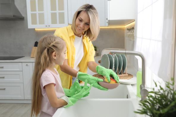Mama sa ćerkom pere sudove