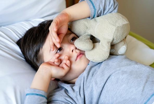 Dečak u krevetu sa plišanom igračkom