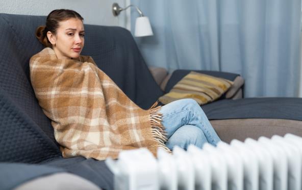 Žena pokrivena ćebetom u hladnoj kući